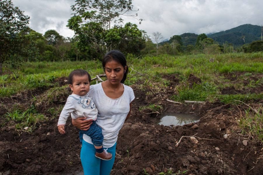 A woman who was evicted from her home in San Marcos on September 30, 2015, searches the location where her house was for belongings. The location for the Mirador Mine pit is just beyond the nearest ridge in the distance. Photo by Beth Wald.